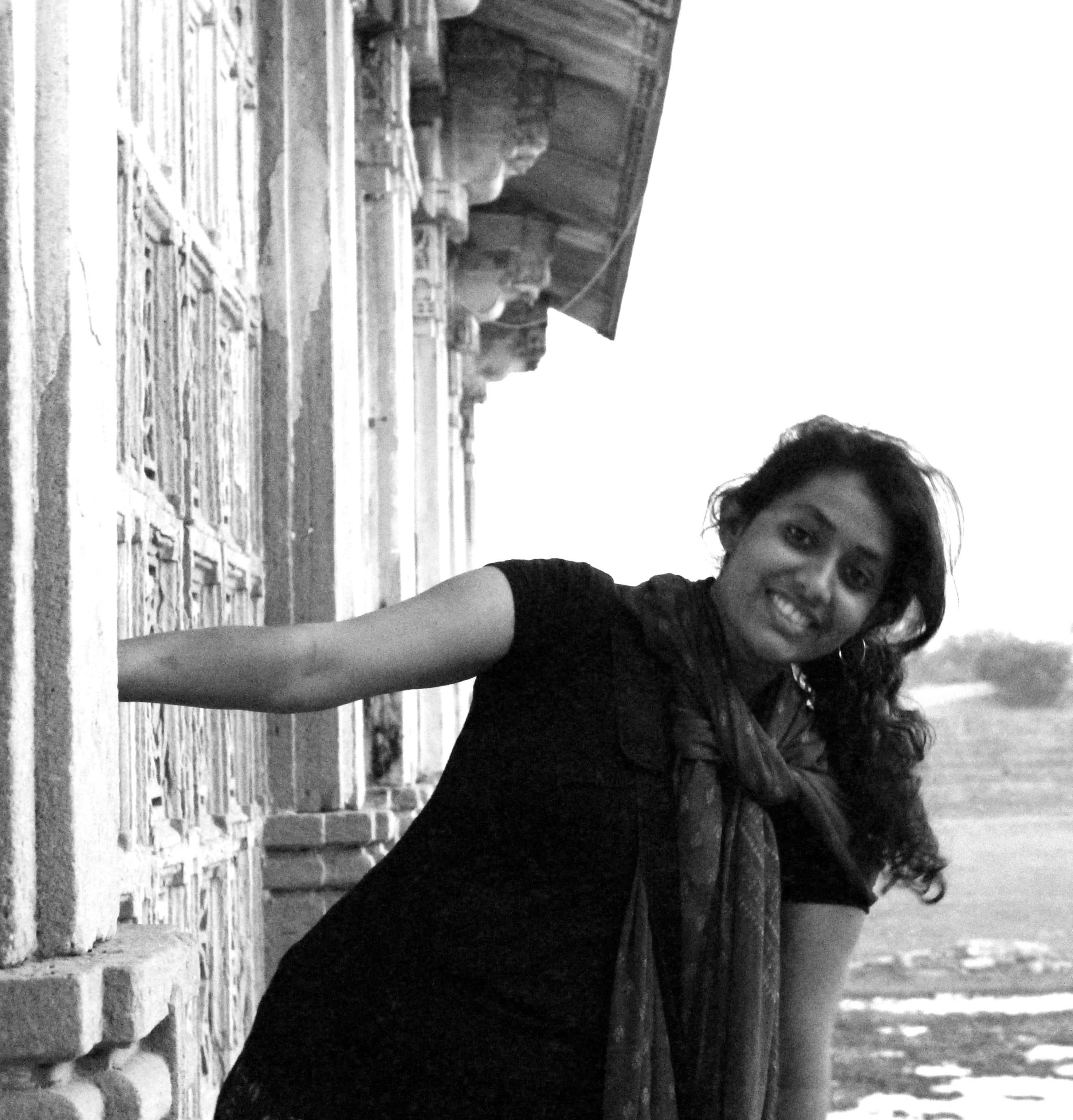 Chandra leaning from an architectural wall